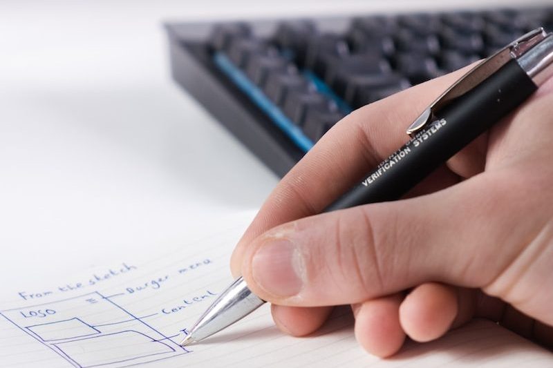 person writing on white paper