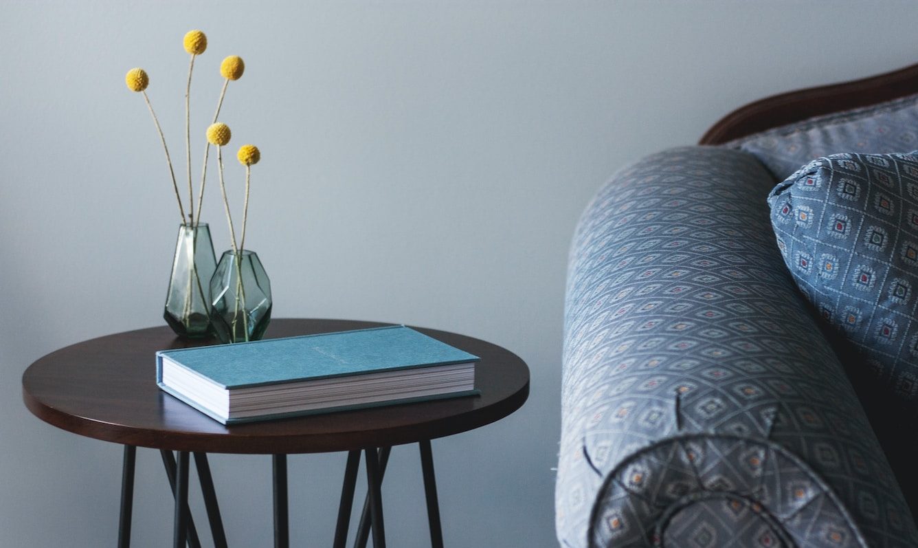blue book on round brown end table near sofa